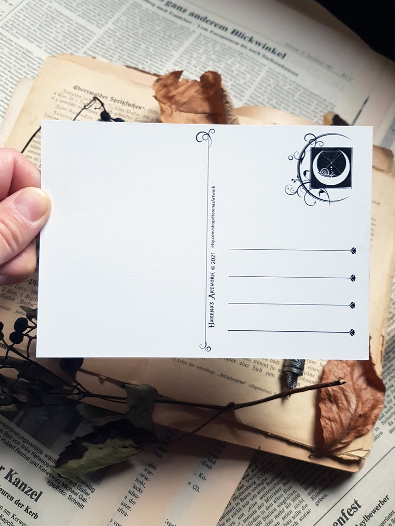 May include: A white postcard featuring a black and white illustration of a crescent moon with a snail inside. The moon is surrounded by a decorative floral design. The text "HARENA'S ARTWORK &copy; 2021 etsy.com/shop/HarenasArtwork" is printed on the back of the postcard.