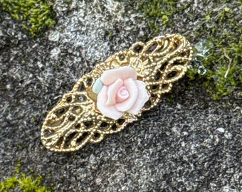 Épinglette/broche avec rose en porcelaine rose sur barrette dorée en filigrane