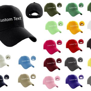 May include: A collection of 20 blank baseball caps in various colors, including black, green, yellow, white, red, pink, blue, gray, and beige. Each cap has a white embroidered label that says "Custom Text".