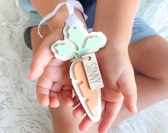 May include: A wooden carrot-shaped ornament with a green leaf design and a tag that says "Sonny".