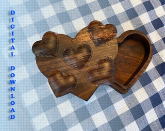 Puede incluir: Una caja de madera en forma de corazón con una tapa con bisagras. La caja está tallada con varios corazones más pequeños y tiene un acabado de madera natural.