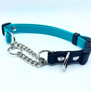 May include: A teal and black dog collar with a silver chain and hardware. The collar has a plastic buckle and a metal ring for leash attachment. The collar is designed for medium to large dogs.