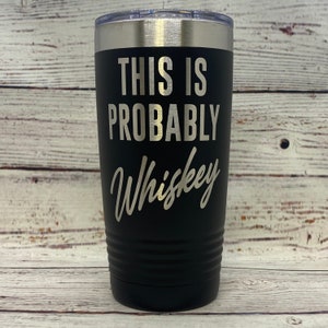 May include: Black stainless steel tumbler with a silver lid. The tumbler has the text "This is probably whiskey" printed on it.