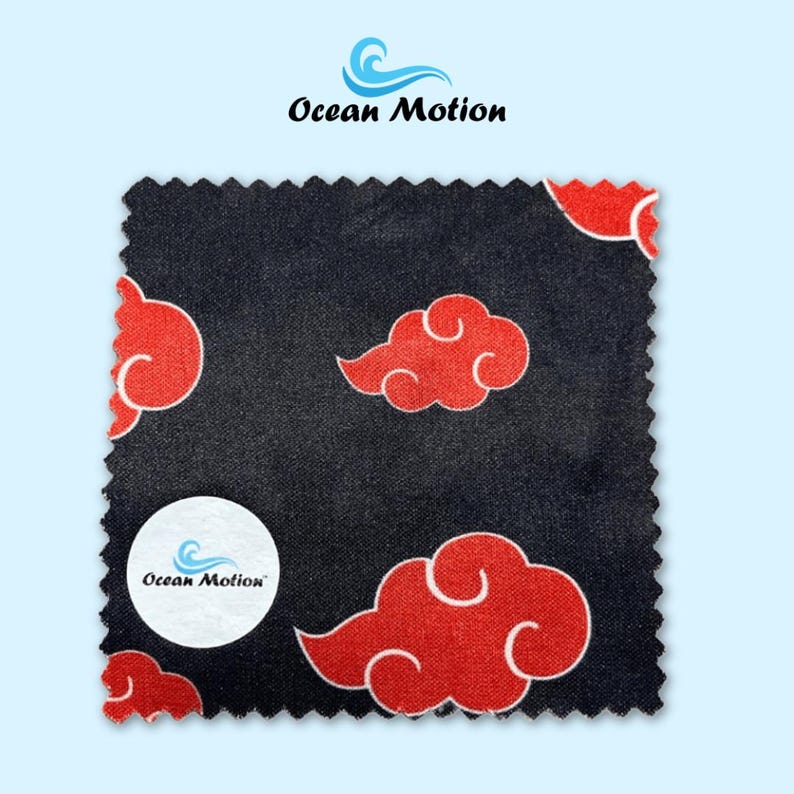 Op de afbeelding: Een vierkant zwart stuk stof met een herhaald patroon van rode wolken met witte contouren. Een wit cirkelvormig logo met de tekst "Ocean Motion" staat linksonder. Het logo "Ocean Motion" staat ook bovenaan.