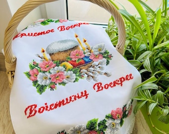 May include: White embroidered cloth with a basket of Easter eggs, a cake, and candles. The text "Христос Воскрес" and "Воистину Воскрес" is embroidered in red.