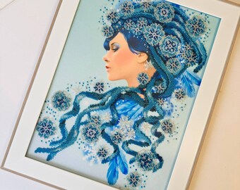 Könnte beinhalten: Ein gerahmtes Kunstwerk, das eine Frau mit blauen Haaren zeigt, die mit Schneeflocken und Federn geschmückt sind. Der Hintergrund ist hellblau mit einem subtilen Glitzereffekt.