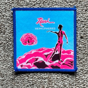 May include: A square patch with a blue border features a vibrant design. The image showcases a pink brain and a figure on a pink landscape against a bright blue background. The word "Rush" and "Hemispheres" are written in red.