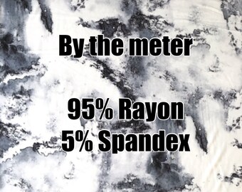 Puede incluir: Primer plano de una tela blanca con un patrón de mármol negro y gris. La tela se vende por metro y está hecha de 95% rayón y 5% spandex.