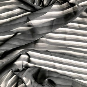 May include: Black and white striped sheer fabric with a soft, flowing texture.
