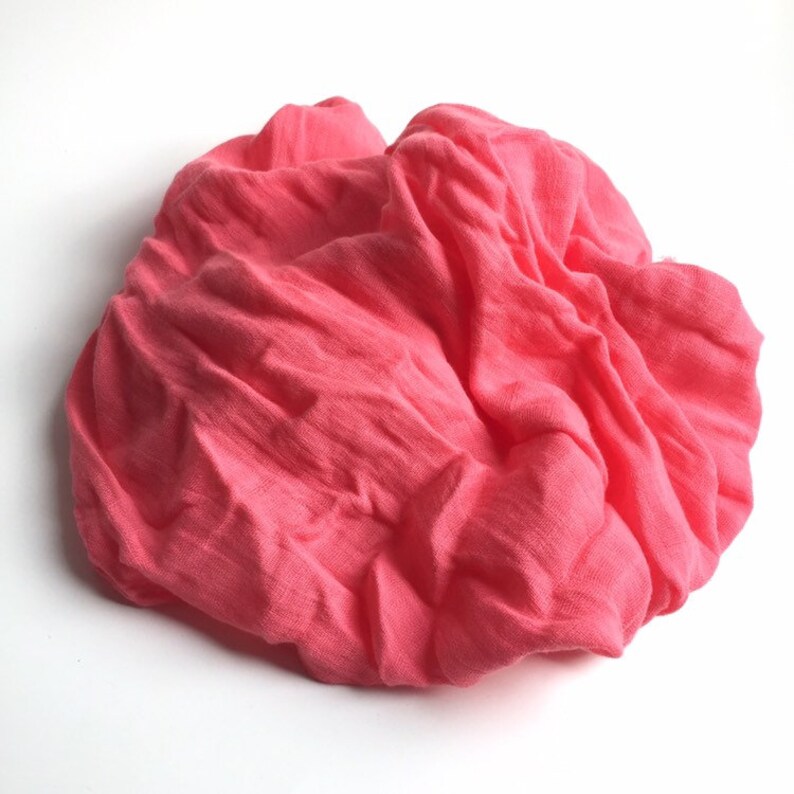 May include: A soft, pink fabric swathe, crumpled and folded, creating a textured, organic shape.