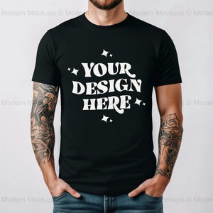 Puede incluir: Una camiseta negra con un gráfico blanco que dice "YOUR DESIGN HERE" con estrellas alrededor del texto.