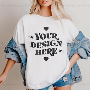 Puede incluir: Una camiseta blanca con un gráfico negro que dice "YOUR DESIGN HERE" con corazones y estrellas alrededor del texto.
