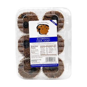 May include: A clear plastic container with six blueberry fiber cakes. The cakes are brown and have a slightly crumbly texture. The label on the container reads "Zen Bakery Blueberry Fiber Cake" and includes nutritional information. The container is labeled "Vegan".