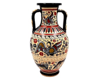 May include: A black and white ceramic amphora with a red and yellow geometric design. The amphora has two handles and is decorated with stylized birds and floral motifs.