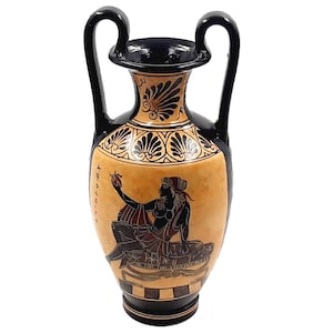 Puede incluir: Jarrón griego de ánfora negro y naranja con detalles pintados en blanco y negro. El jarrón representa a una mujer sosteniendo una fruta roja. El jarrón tiene dos asas.