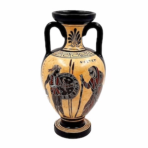 Puede incluir: Una ánfora griega negra y roja con una escena de dos figuras, una sosteniendo un escudo y la otra una lanza. La ánfora está decorada con un patrón geométrico blanco y negro y la inscripción "NESTOR".