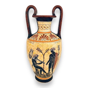 Puede incluir: Una ánfora griega blanca y naranja con dos asas, que representa dos figuras en silueta negra. La ánfora está decorada con un patrón geométrico y el texto "APOLLON" y "DAMAS".