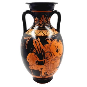 May include: Black and orange Greek amphora with two handles and a scene of three figures painted on the side. The figures are painted in orange and are holding spears and shields. The amphora has a black background and a decorative pattern around the top.