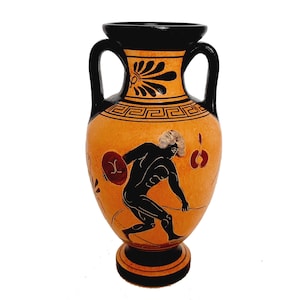May include: A black and orange ceramic amphora with a black and white design of a figure holding a discus. The amphora has two handles and a black base.