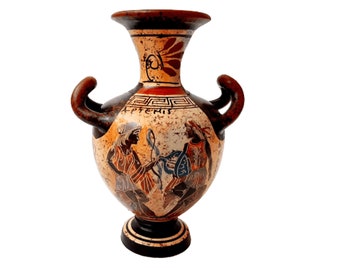 May include: A brown and black ceramic vase with two handles. The vase is decorated with a red and white geometric pattern and a scene of two figures in black, white, and blue. The vase is inscribed with the Greek word "ΑΡΤΕΜΙΣ".