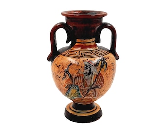 May include: A small, brown ceramic amphora with two handles. The amphora is decorated with a black and white geometric pattern and a painted scene of a figure holding a staff.