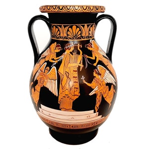 May include: A black and orange Greek amphora with two handles and a scene of winged figures painted on the body. The figures are painted in orange and white on a black background. The amphora has a black base and a black lid with a decorative orange band.