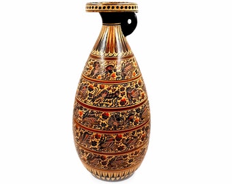 May include: A tall, brown ceramic vase with a black top and handle. The vase is decorated with intricate floral and geometric patterns in shades of gold, red, and black.