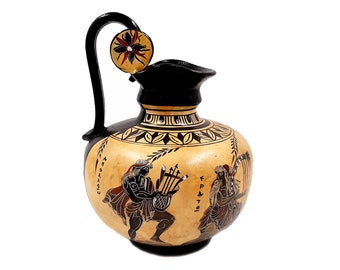 May include: A black and brown ceramic pitcher with a floral design on the lid. The pitcher features a scene of two figures playing musical instruments, with Greek writing on the side.
