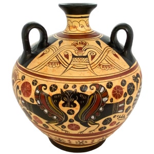 May include: A black and white ceramic vase with a geometric design and two handles. The vase is decorated with red, yellow, and brown paint.