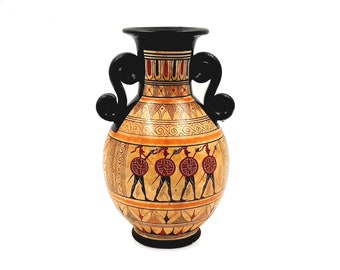 May include: A black and orange ceramic vase with two black handles. The vase is decorated with a geometric pattern and a scene of warriors with shields and spears.
