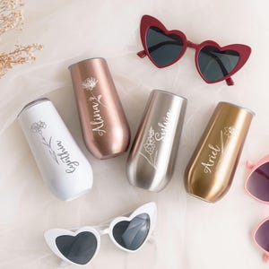 a collection of personalized items, including wine glasses, sunglasses, and a veil, arranged on a light-colored background.