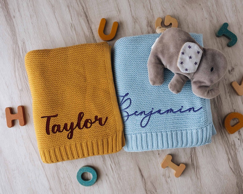 a stuffed animal laying on top of a blue and yellow blanket