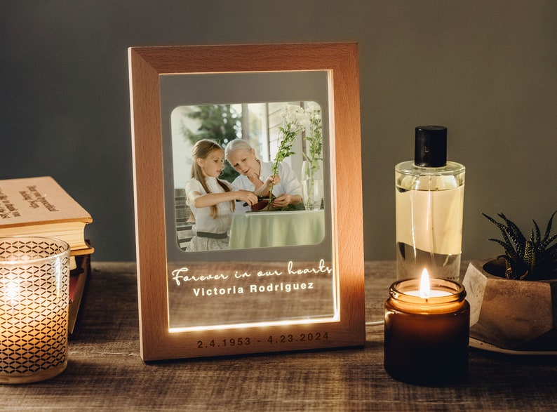 a picture frame sitting on a table next to a candle