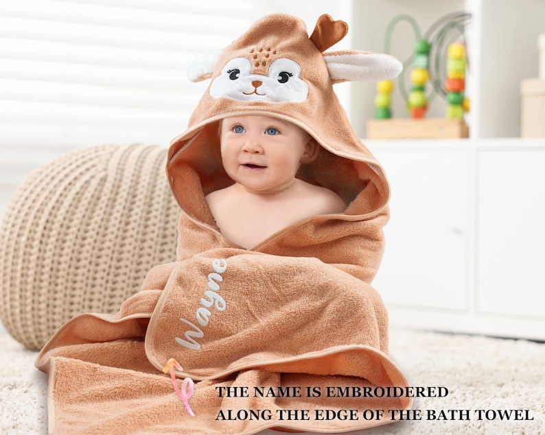 a baby wrapped in a towel with a giraffe face on it