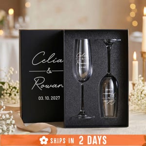 A black box containing two wine glasses, with the text "Celia & Rowan" and the date "03.10.2027" printed on it.
