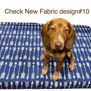 May include: A brown and white dog sitting on a blue dog bed with a white arrow pattern. The bed has a yellow border. The text "Check New Fabric design#10" is visible at the top of the image.