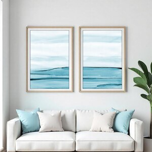 Set of two blue ocean watercolor prints featuring abstract coastal landscapes with soft waves, beach-inspired textures, and calming seaside tones. Coastal wall art set, ocean watercolor print duo, abstract beach wall decor, blue ocean print set of 2, printable coastal artwork for living room, bedroom, beach house, nautical decor, minimalist watercolor ocean art digital download. Designed by CheerfulWatercolors