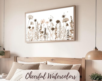 May include: A framed watercolor print featuring a field of wildflowers in shades of brown and beige against a white background. The artwork is displayed above a bed. The text "Cheerful Watercolors" is visible on a pillow.
