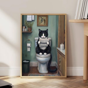 以下が含まれることがあります： バスルームの白いトイレに座って新聞を読んでいる黒と白の猫。バスルームは緑色の壁、木製のキャビネット、白いタオル掛けがあります。