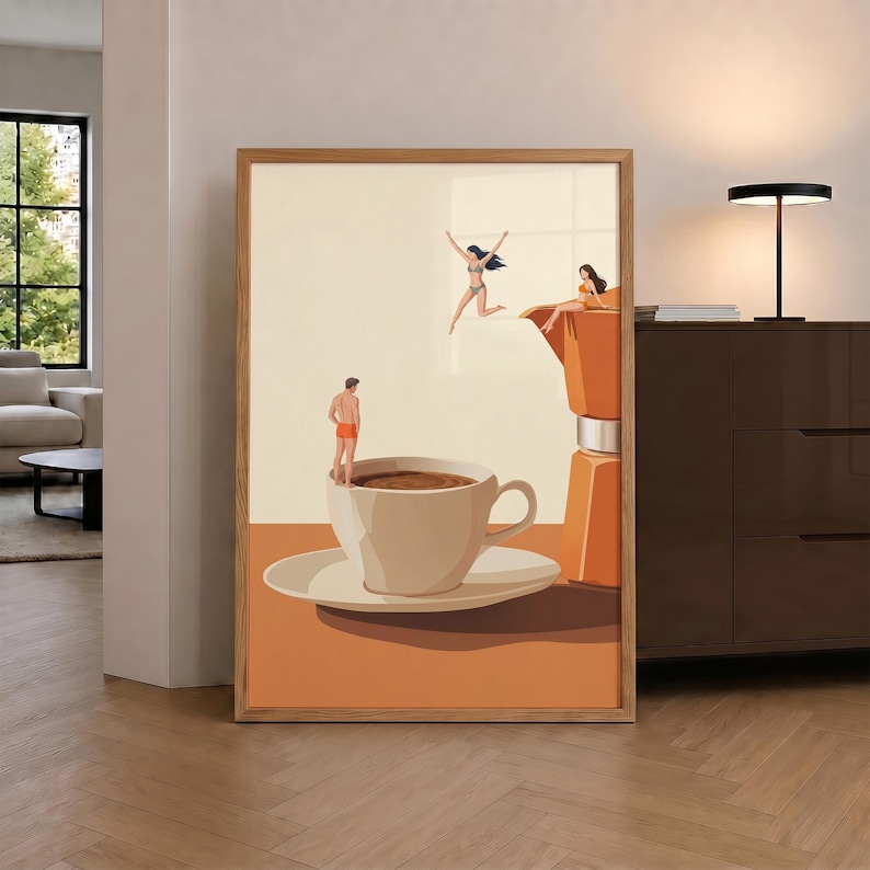 May include: A framed wall art print featuring a surreal illustration of a large coffee cup and a moka pot. Tiny figures in swimwear are depicted jumping into and sitting on the edge of the coffee cup and the moka pot, set against a cream background.