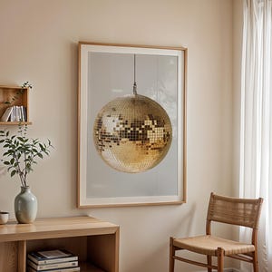 May include: A framed print of a gold disco ball hanging from the ceiling against a white background.