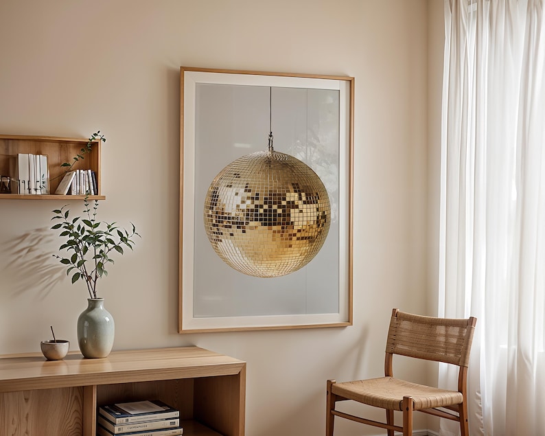 May include: A framed print of a gold disco ball hanging from the ceiling against a white background.