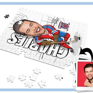 May include: A white jigsaw puzzle with a cartoon illustration of a hockey player. The player is wearing a red, white, and blue jersey with the number 5 on it. The puzzle is partially assembled and the player's name, "Charles", is written in black letters on the puzzle. The puzzle is on a white surface with a few puzzle pieces scattered around it. A photo of a couple is in the background.