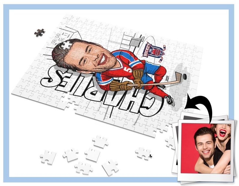 May include: A white jigsaw puzzle with a cartoon illustration of a hockey player. The player is wearing a red, white, and blue jersey with the number 5 on it. The puzzle is partially assembled and the player's name, "Charles", is written in black letters on the puzzle. The puzzle is on a white surface with a few puzzle pieces scattered around it. A photo of a couple is in the background.