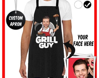 May include: Black custom apron with a cartoon chef holding a spatula and a steak. The text "Grill Guy" is printed on the apron. A photo of a person's face can be added to the apron.