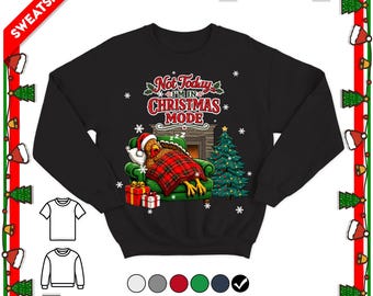 May include: A black long-sleeve sweatshirt featuring a graphic of a turkey wearing a Santa hat, sleeping in a green armchair under a red plaid blanket. The text reads Not Today I'M IN CHRISTMAS MODE, with a Christmas tree and gifts nearby.