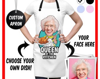 May include: White apron with a cartoon image of a woman holding a spatula and a plate of food. The text "Queen of the Kitchen" is printed below the image. The apron is customizable with a photo of your face.