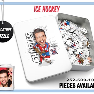 May include: A caricature puzzle in a white tin box with a cartoon image of a hockey player. The player is wearing a red, white, and blue jersey with the name "CHARLES" on the back. The puzzle is available in 252, 500, and 1000 pieces.