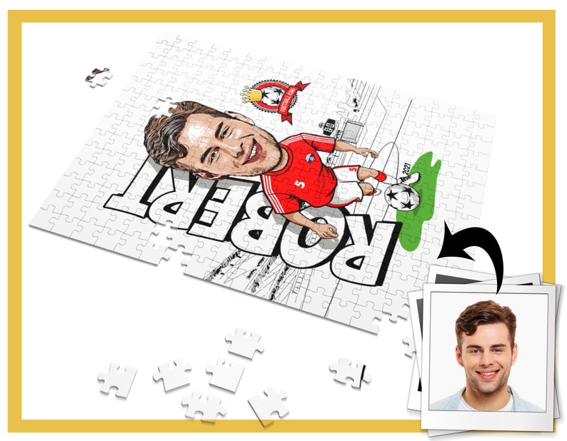 May include: A white jigsaw puzzle with a cartoon illustration of a soccer player in a red and white jersey. The puzzle is partially assembled and the player's name "Robert" is visible. A photo of a man is in the background.