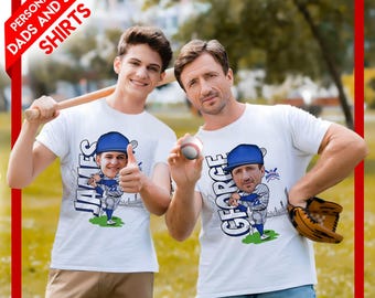 May include: Two white t-shirts with baseball-themed cartoon graphics. One shirt features the name "JAMES" and a cartoon baseball player giving a thumbs up. The other shirt has the name "GEORGE" and a baseball player. Text on the top left says "PERSONALIZED DADS AND SONS SHIRTS".